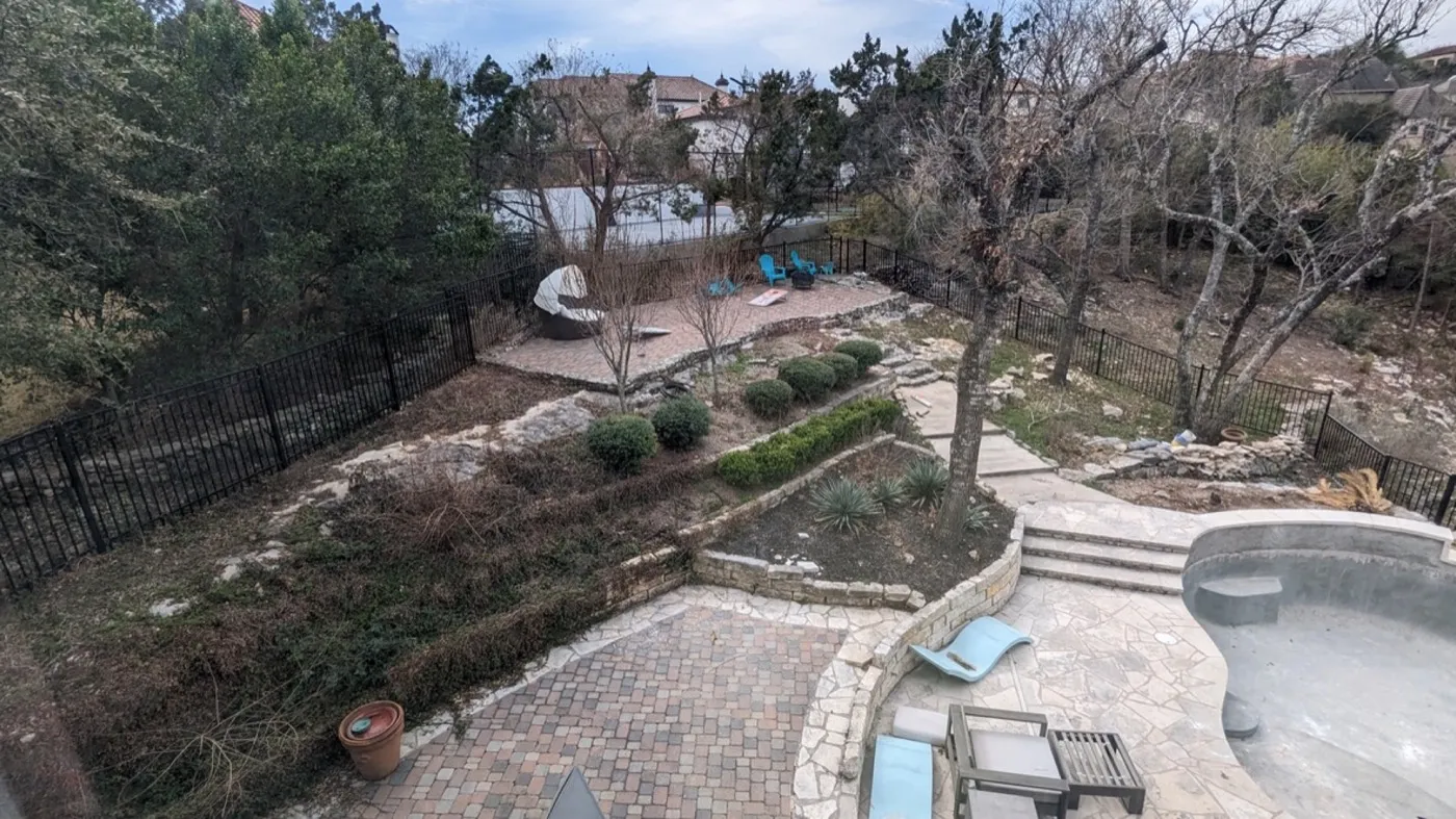 The Clarion Cove back slope before work began — bare soil and mismatched rubble walls