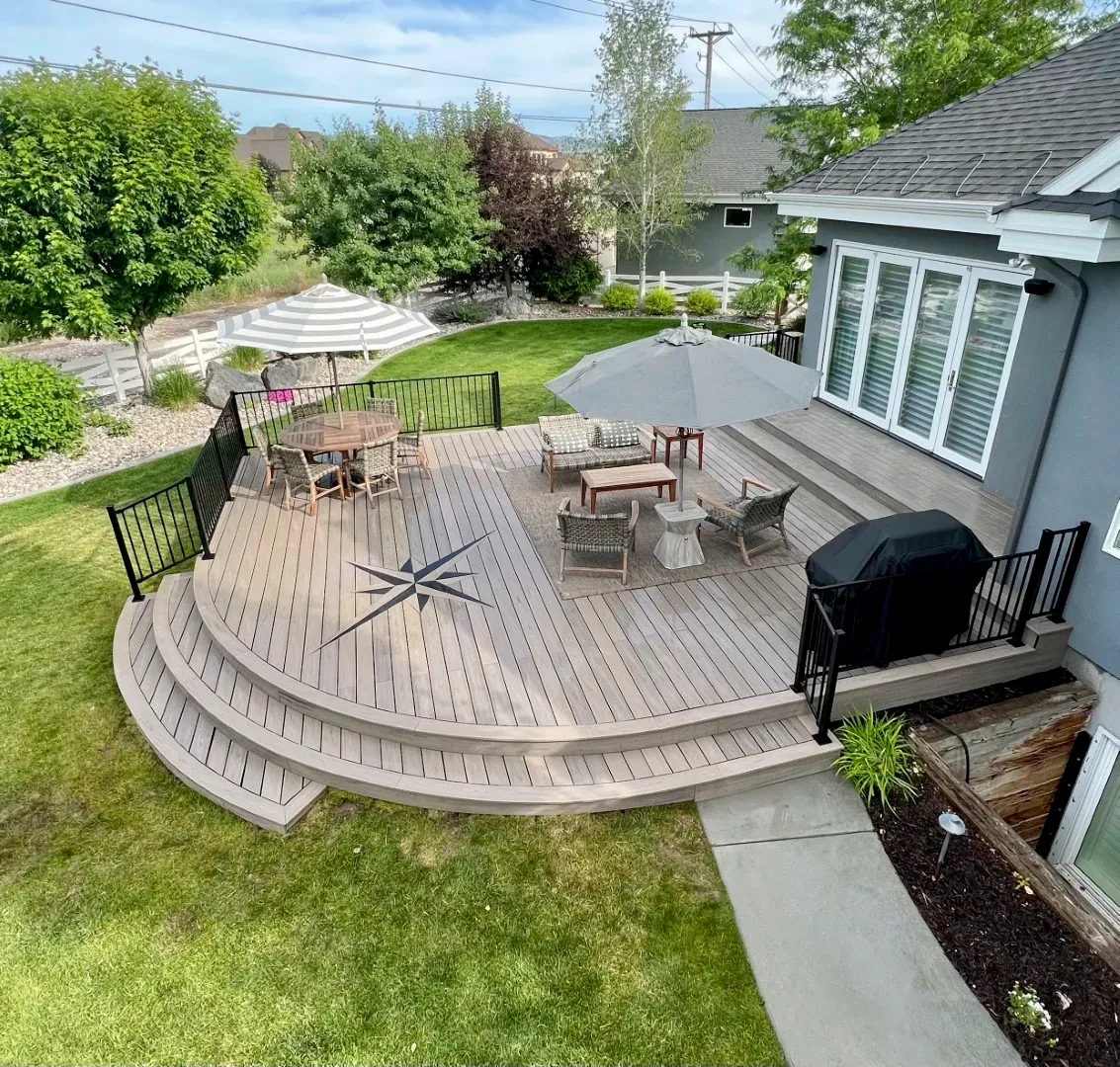 Cedar deck seen from inside the home through open glass doors, evening light spilling outward