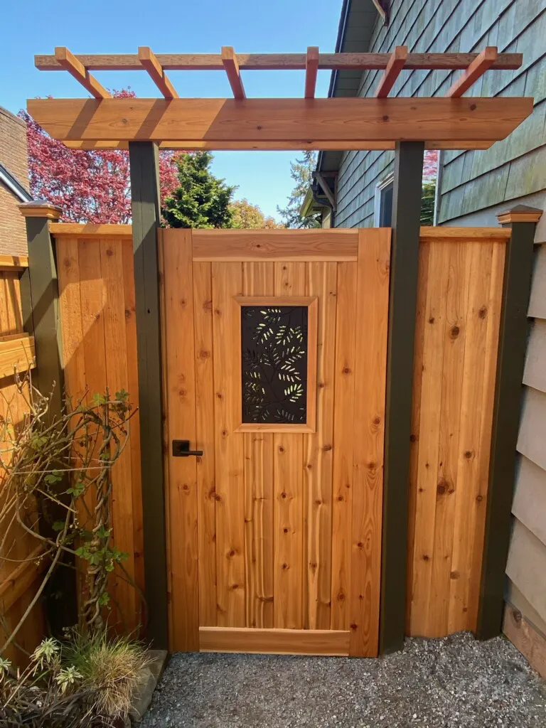 A custom cedar gate with solid stain and black hardware at an Austin property