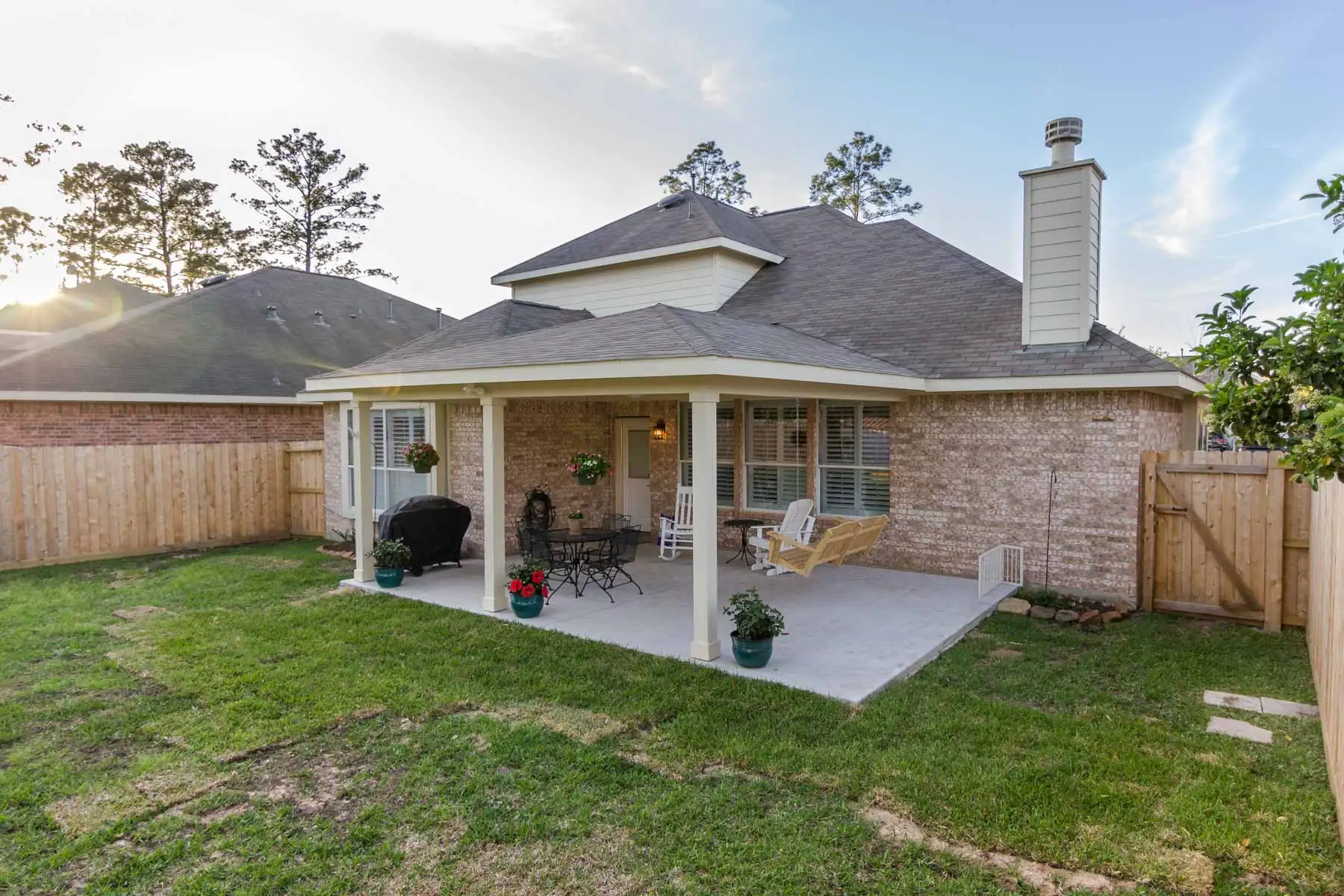 Solid-roof patio cover with white columns and shingles matching the house