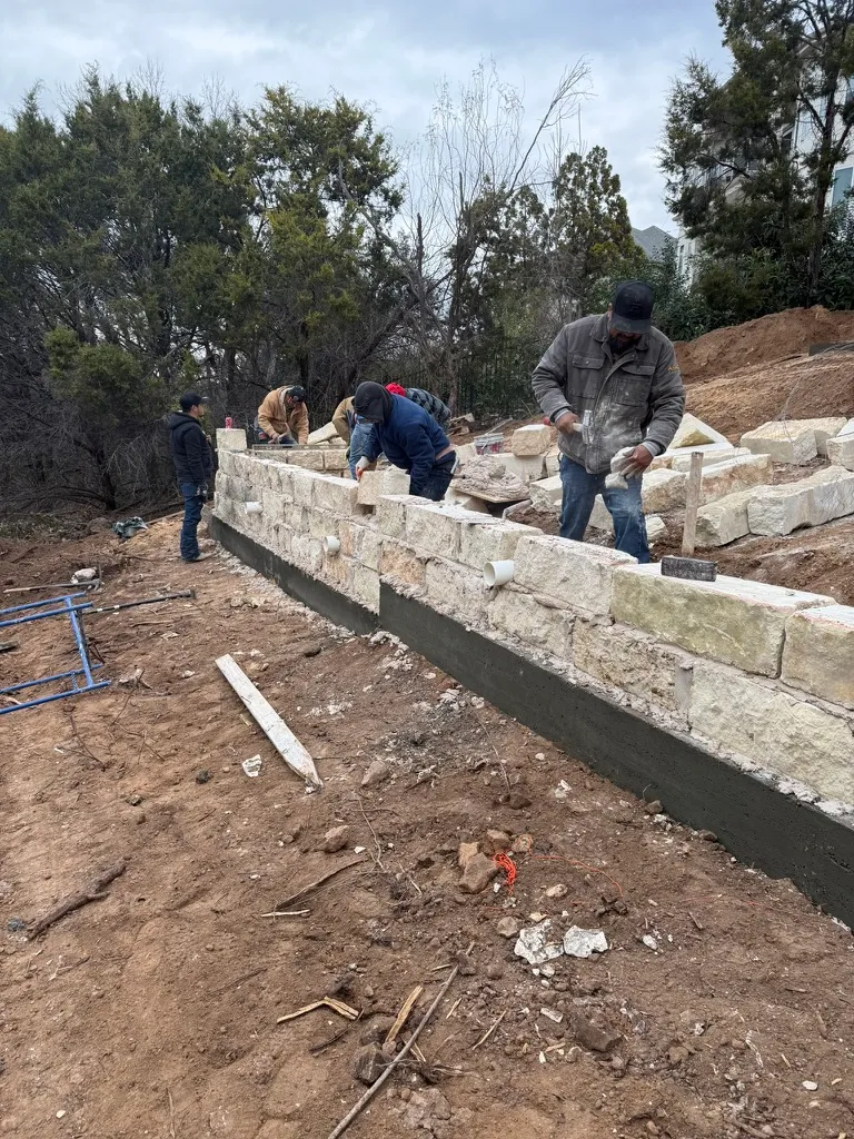 Beautifully terraced limestone retaining walls creating multiple levels of usable outdoor space on a West Austin hillside property