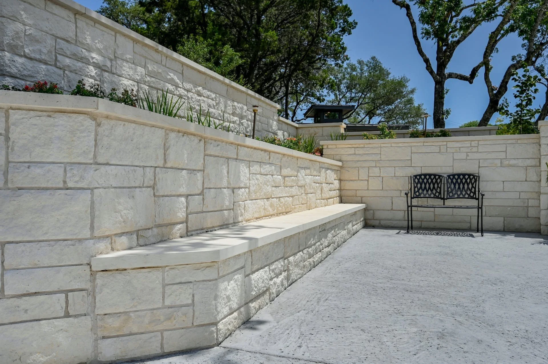 Tiered limestone retaining wall with integrated landscaping