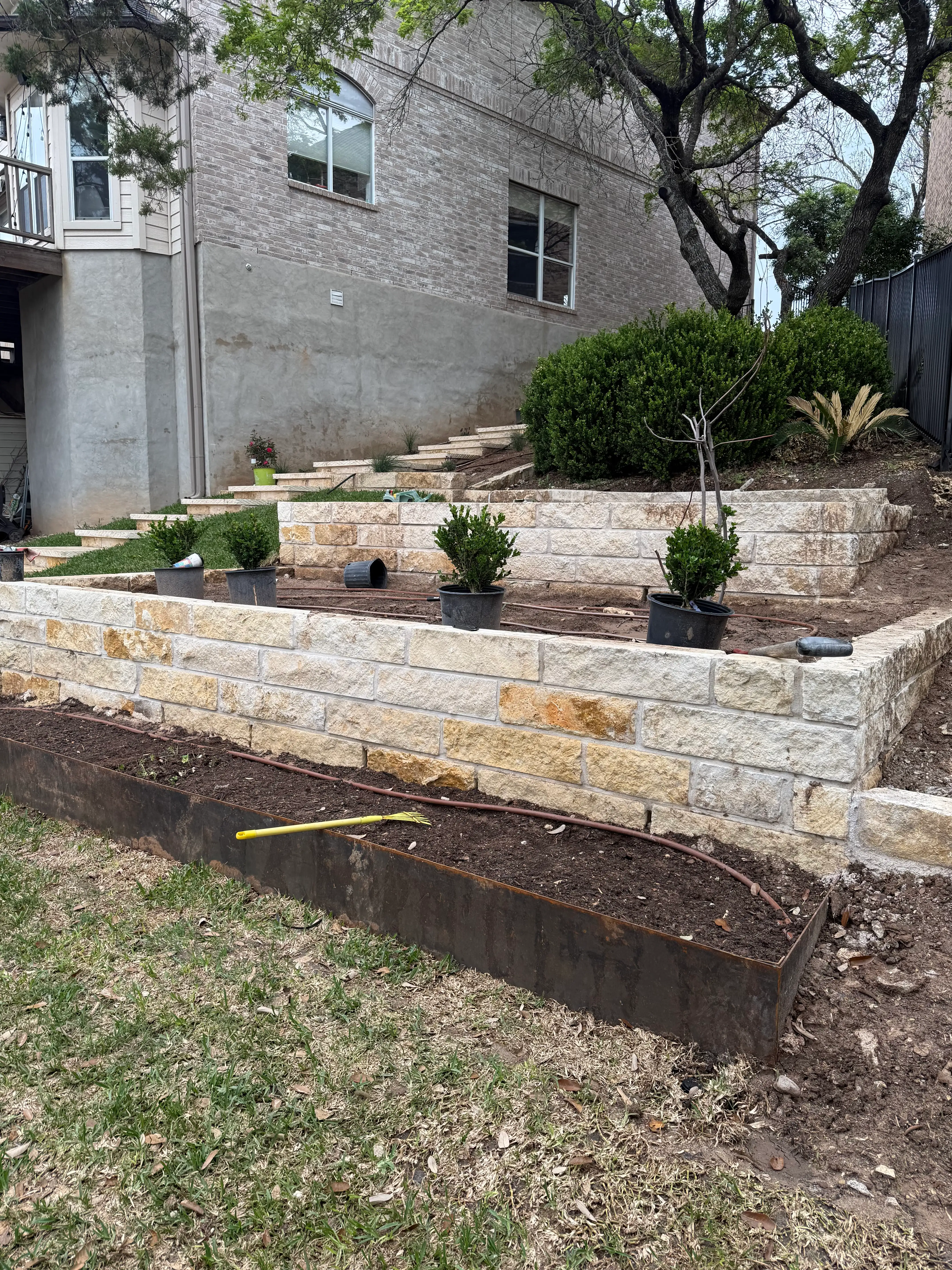 Two tiers of limestone walls with steel edging and new planting