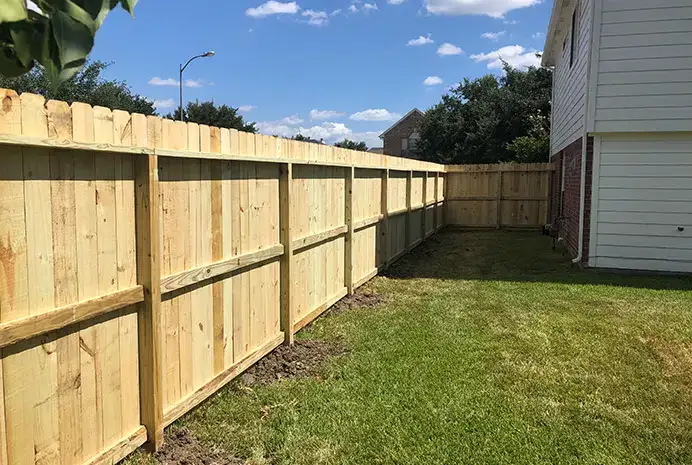 New treated pine privacy fence along the side of a home