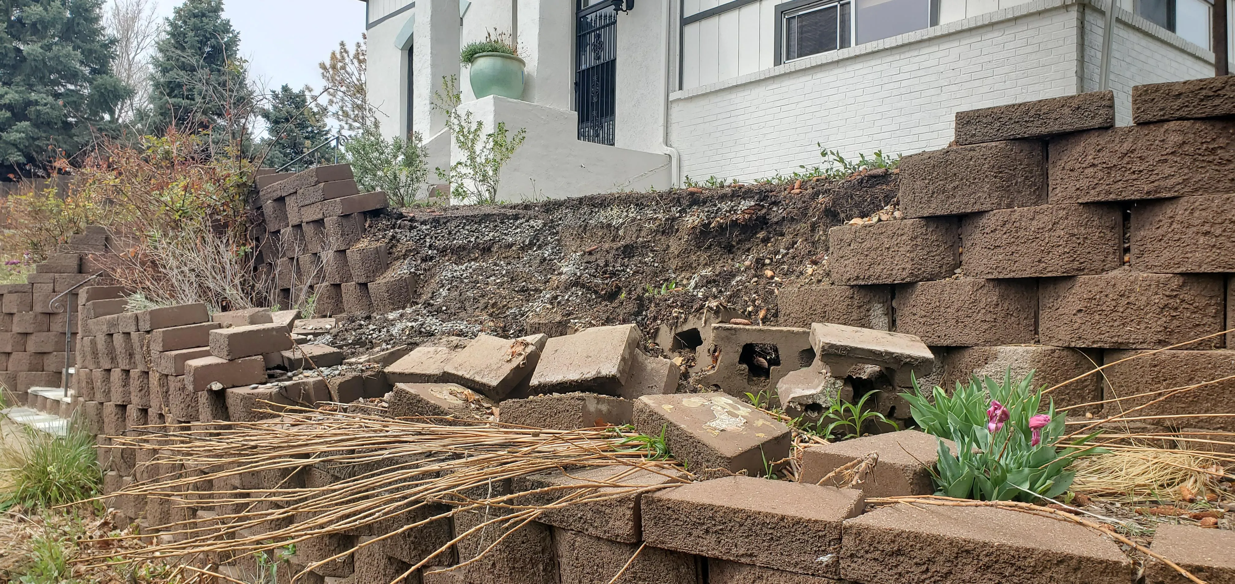 Failed retaining wall — collapsed blocks and displaced masonry