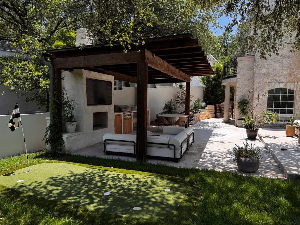 Heavy timber patio cover framing casting deep shade on a Central Texas residential property